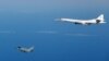 An RAF Typhoon fighter aircraft (left) flies close to a Russian strategic Tupolev TU-160 bomber in September 2015.