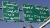 Workers add Turkoman language translations to traffic signs in multiethnic Kirkuk.