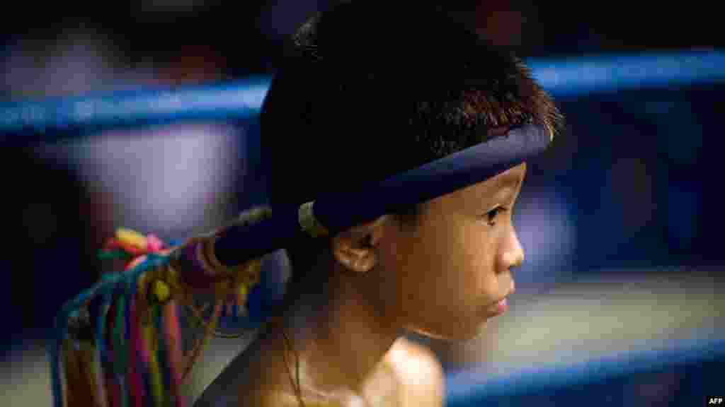 A child Muay Thai boxer focuses inside the ring ahead of his fight