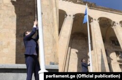 Спікер парламенту Грузії Кахабер Кучава піднімає прапор Євросоюзу біля будівлі парламенту