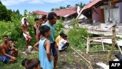 Ljudi ispred urušene zgrade nakon zemljotresa u gradu Bogo, 1. oktobra 2025.