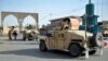 Afghan security guards walk during a Taliban attack in Ghazni city, August 12, 2018