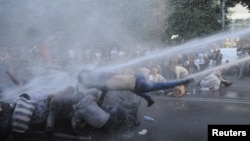 Armenia -- Protesters are hit by a jet of water released from a riot police vehicle during a rally against a recent decision to increase the tariff on electricity, in Yerevan, June 23, 2015.