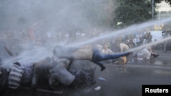 Ереванда электр қуаты тарифтерінің қымбаттауына қарсылық танытқан демонстранттарды полиция сумен атқылап қуып таратып жатыр. Армения, 23 маусым 2015 жыл.