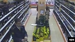 A TV grab shows former police officer Denis Yevsyukov reloading his pistol in a Moscow supermarket on April 27, 2009. 