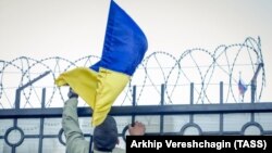 Украина туын қоршауға тікпек болып тұрған адам (Көрнекі сурет)