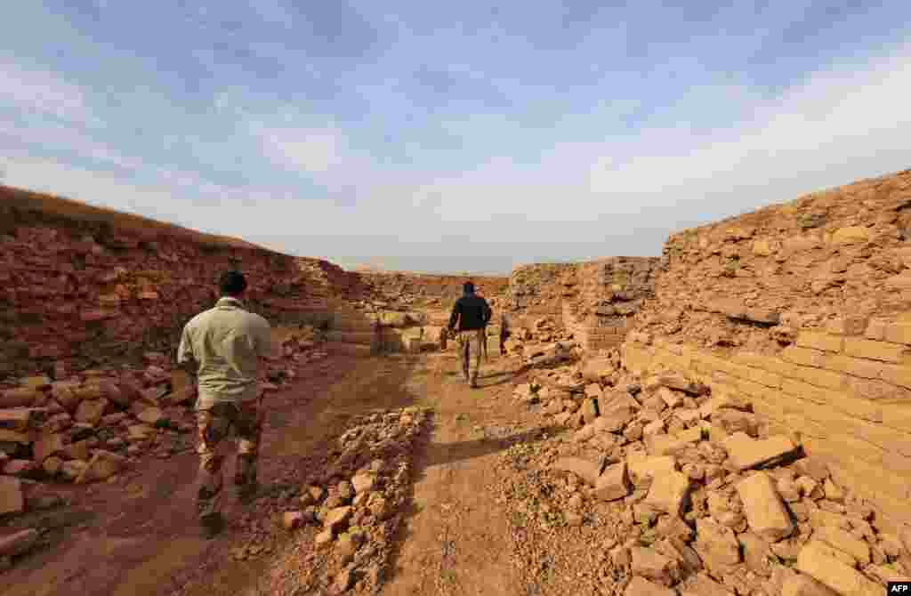 Soldiers walk through the ancient ruins.