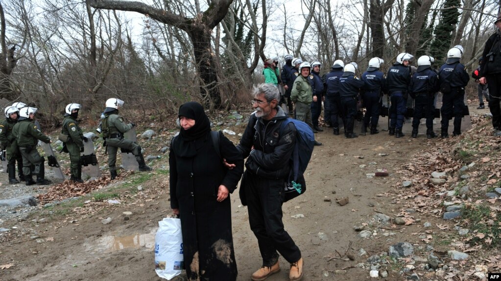 Migrants pass security forces on their way to Macedonia and the Balkans route to the European Union