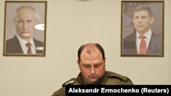 Noel șef din Donețk Dmitri Trapeznikov cu portretele lui Putin și Aleksandr Zaharcenko.