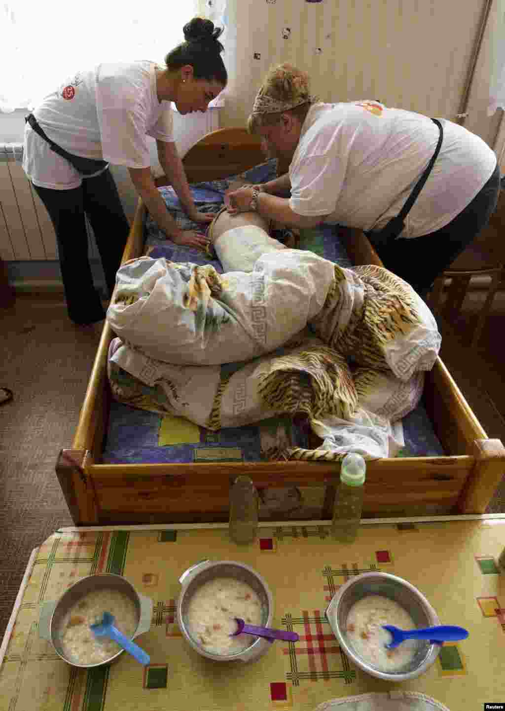 Laura Murphy and Trina Gilchriest perform a check-up on a child.