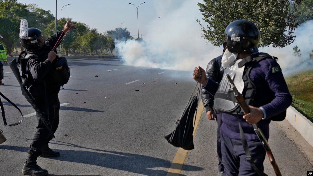 Pakistani police fire tear gas toward protesters marching toward Islamabad on November 26.