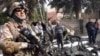 An Iraqi soldier stands guard at the scene of a suicide car bomb attack at Al-senaa district, central Baghdad, 15 Feb