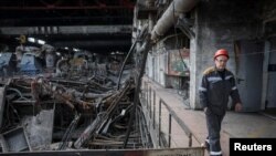 Работник поминува низ термоцентрала оштетена од руски ракетен напад на непозната локација во Украина на 8 април 2024 