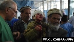 Авганистански маж држи дете во рацете по експлозија на автомобил бомба во Кабул. 27 јануари 2018 