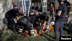 Rescuers prepare to carry the body of a person killed during Russian air strikes on the village of Lyptsi, in Ukraine's Kharkiv region, on April 10.
