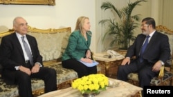 Egypt's Foreign Minister Mohamed Kamel Amr (left to right), U.S. Secretary of State Hillary Clinton, and Egyptian President Muhammad Morsi meet at the presidential palace in Cairo on November 21.