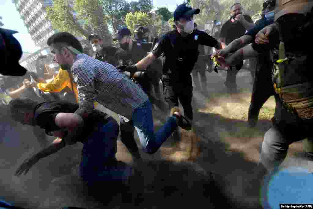 Opposition supporters clash with police during a rally against a bill to limit the Ukrainian language in schools outside the parliament in Kyiv on July 17. A deputy in the party of President Volodymyr Zelenskiy has proposed legislation that would reduce the use of Ukrainian language in schools. A large proportion of the population speaks Russian, which was the dominant language in the Soviet Union and the tsarist era. Critics of the bill say it paves the way for the &quot;total Russification of education.&quot; (AFP/Sergei Supinsky)