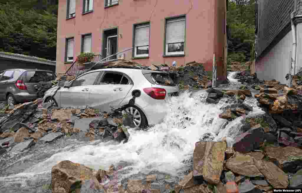 В Хагене, Германия, в четверг, 15 июля 2021 года, автомобили засыпаны обломками, принесенными накануне вечером наводнением реки Нахма