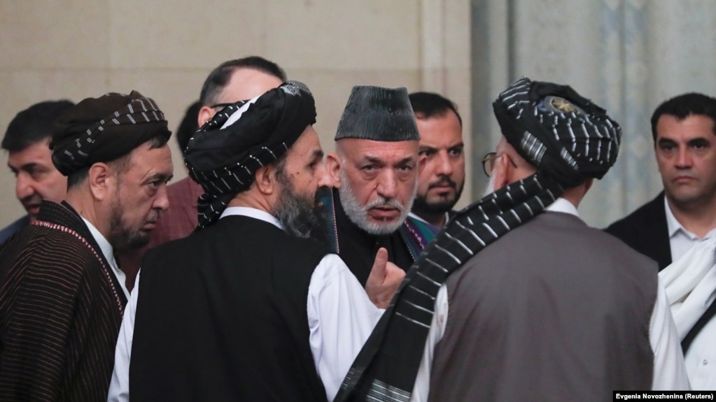 FILE: Former Afghan President Hamid Karzai (2nd R) and cheif Taliban negotiator Mullah Abdul Ghani Baradar (3rd R) talk in Moscow.