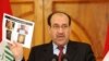 Iraqi Prime Minister Nuri al-Maliki displays photographs showing the body of Abu Omar al-Baghdadi during a news conference today.