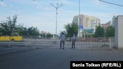 Двое полицейских стоят у ограждения на центральной площади в Атырау. 22 мая 2016 года