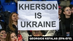 Женщина держит плакат «Херсон – это Украина»