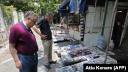 People reading headlines in front of a newspaper stand in the Iranian capital Tehran, May 20, 2019 - FILE PHOTO