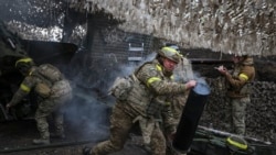 Soldiers from the 15th Brigade of Ukraine's National Guard of Ukraine fire artillery near Kupyansk in May. 