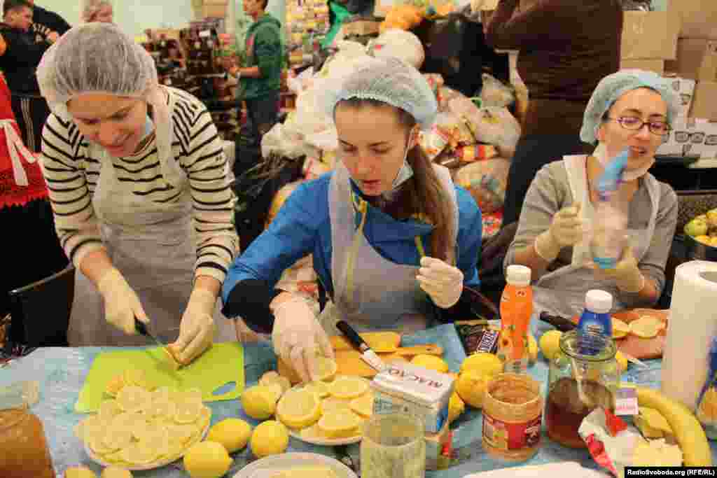 Young women sing Ukrainian folk songs while cutting fruit and preparing sandwiches. 