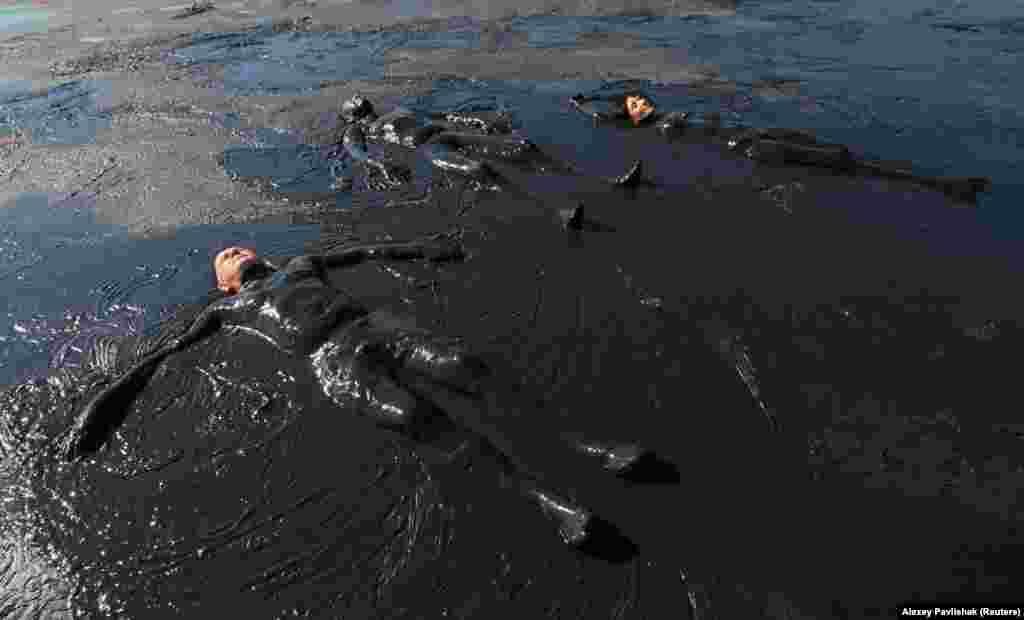Людзі прымаюць гразевыя ванны ў возеры Чакрак каля вёскі Курортнае ў Крыме 