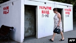 O locuitoare din Sevastopol trece pe lângă un adăpost, 22 iulie 2026. Foto: AFP