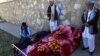 Afghan men stand over dead bodies at the site of an attack by Taliban militants on a government compound in the Khwaja Omari district in Ghazni Province on April 12.