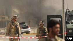 Security forces walk at the site of a suicide bomb attack at the main gate of a NATO military airport in Kabul in September 2009. Two bystanders were killed in the attack.