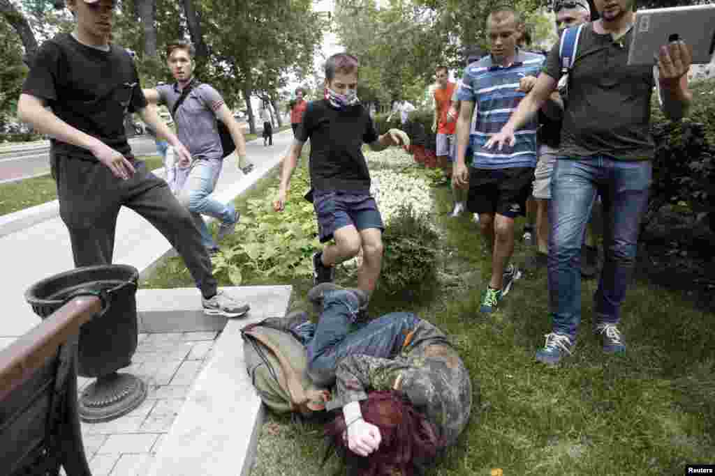 Youths kick a gay-rights activist during a protest against a bill that would outlaw &quot;homosexual propaganda&quot; directed toward minors. Activists say the bill, backed by Russian President Vladimir Putin&#39;s allies in parliament, would prohibit all gay-rights rallies and is fueling violence against gays. (Reuters/Maxim Shemetov)