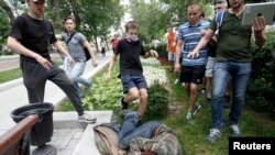Youths kick a gay rights activist during a protest in central Moscow in June, 2013.