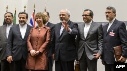 EU foreign policy chief Catherine Ashton (third from left) poses next to Iranian Foreign Minister Mohammad Javad Zarif (third from right) and the Iranian delegation in Geneva after a statement early on November 24 announcing the deal on Iran's nuclear program.