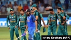 Indian team captain Rohit Sharma (C) and Pakistan team leave the field after India won by 9 wickets during the one day international (ODI) Asia Cup cricket match between Pakistan and India at the Dubai International Cricket Stadium in Dubai on September 23.