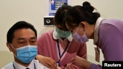 Egy egészségügyi dolgozó megkapja a koronavírus elleni védőoltást Tajpejben, 2021. március 22-én