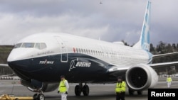 Ground crew members escort a Boeing 737 MAX as it returns from a flight test at Boeing Field in Seattle, Washington, January 29, 2016