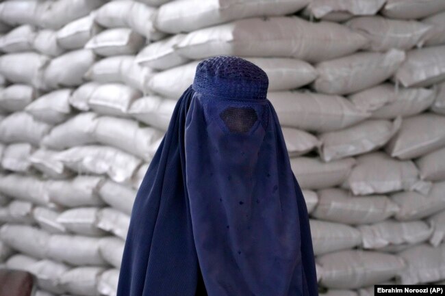 An Afghan woman waits to receive a food ration in Kabul in May 2022.