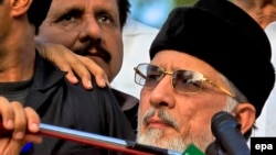 Tahirul Qadri (R), a Pakistani-Canadian cleric, is surrounded by security personnel as he speaks to supporters during protest in Islamabad, Pakistan.