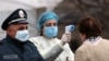 Медична працівниця вимірює температуру жінці в межах заходів запобігання поширенню коронавірусу, Армавір, Вірменія, 16 березня
