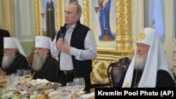 Президент Росії Володимир Путін (із мікрофоном), а праворуч від нього Московський патріарх Кирило, 11 липня 2016 року. Що саме у келихах в ієрархів РПЦ на столі, не повідомляли