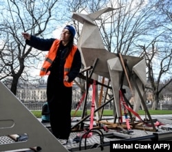 Ukrainian artist Zhanna Kadyrova with the Origami Deer sculpture she will exhibit in Venice. The photo was taken in Prague on March 12 during a tour of the artwork through Europe.