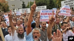 Muslim protesters hold banners reading " Dignity, Justice, Identity" in Pristina