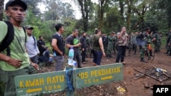 Soldiers along with members of a search-and-rescue team search the location of the Russian Sukhoi Superjet plane crash in Cidahu.