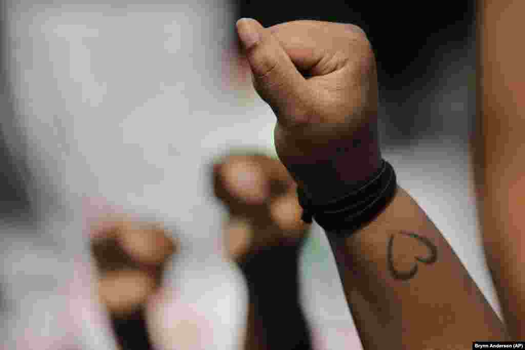 ​Люди тримають стиснуті кулаки під час акції протесту проти неправильного поводження з чорношкірими і дають зрозуміти владі, що вони хочуть зміни політики. Атланта, штат Джорджія, США