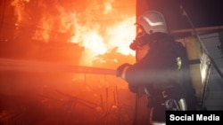 A Ukrainian firefighter battles a blaze on October 6 following a Russian air attack on the port city of Odesa. 