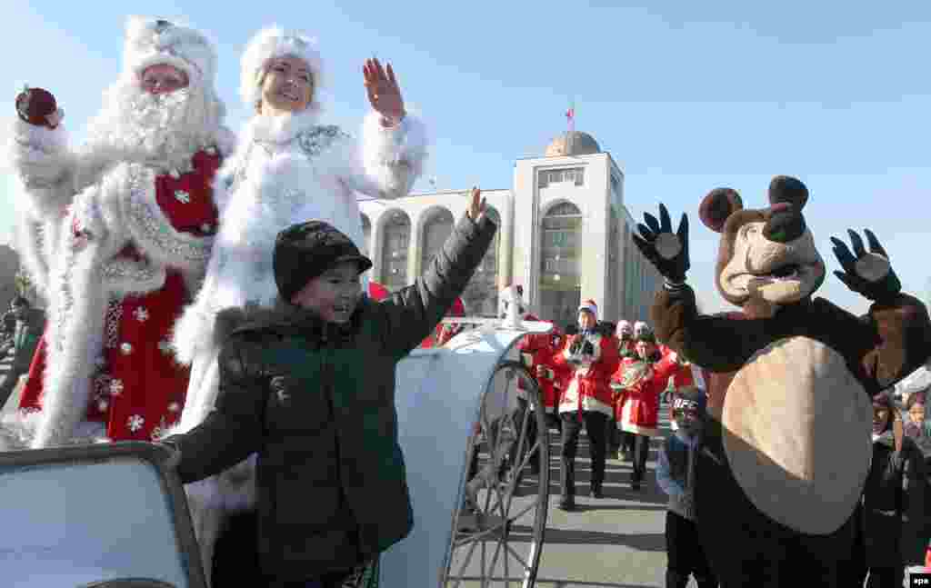 Father Frost and his granddaughter wave from a horse-drawn carriage as they take part in a New Year's parade in Bishkek, Kyrgyzstan. (epa/Igor Kovalenko)