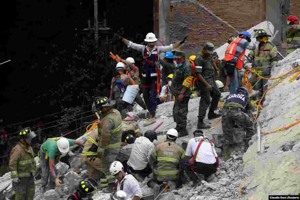 MEXICO -- A rescue worker motions for everybody to be quiet as they are searching for people under the rubble of a collapsed building after an earthquake hit Mexico City, Mexico September 19, 2017